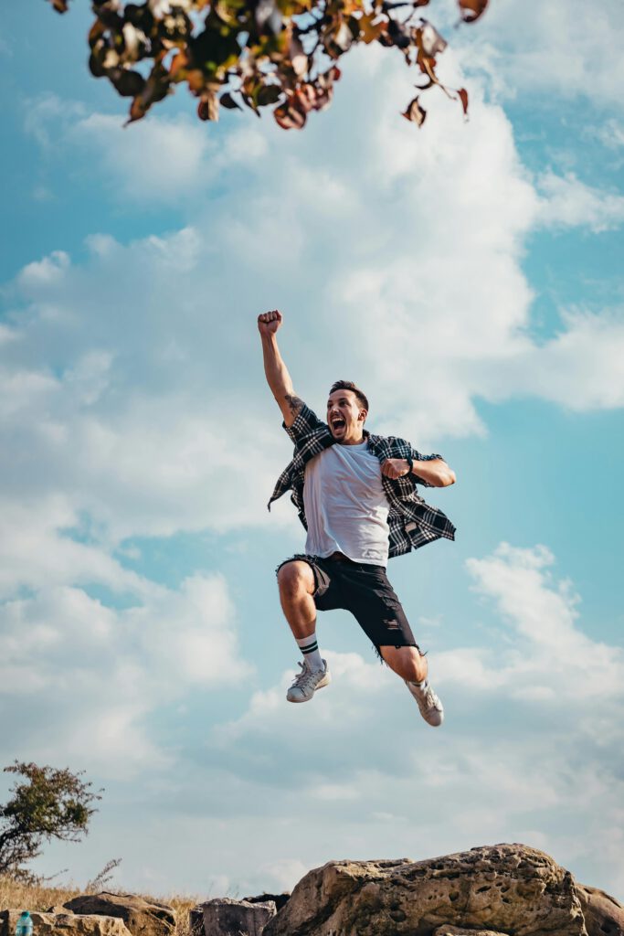 A vibrant image of a young man jumping with joy outdoors, capturing a moment of freedom and exhilaration.